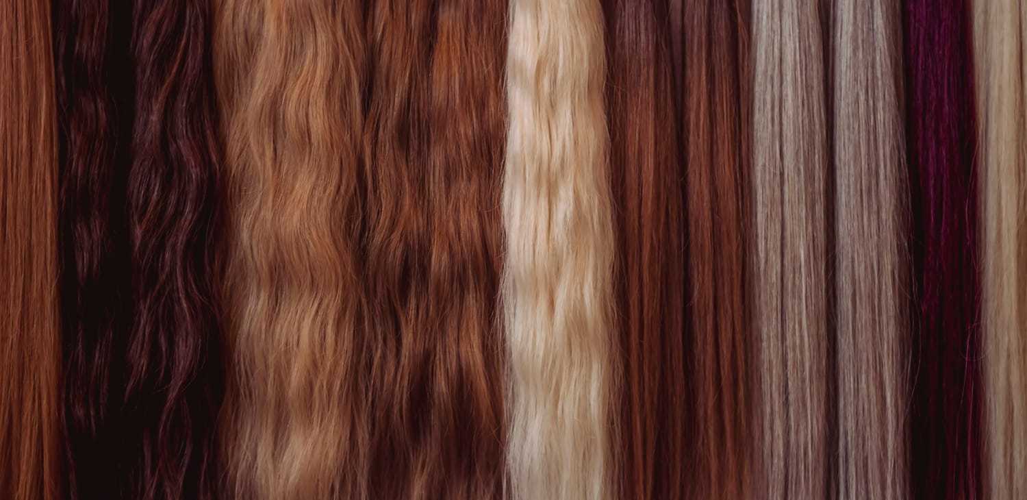 Various shades of hair extensions in brown, blonde, and auburn tones displayed vertically.