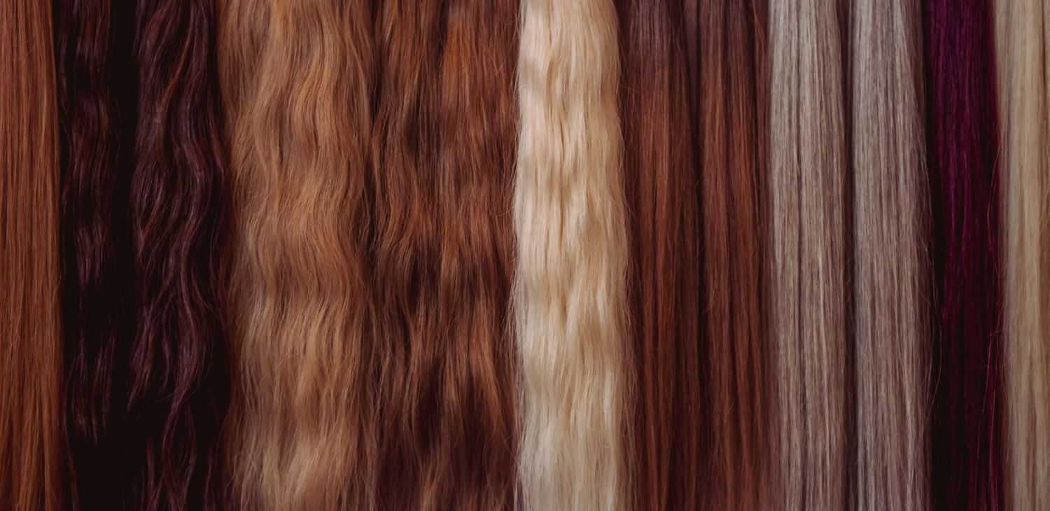 Various shades of hair extensions in brown, blonde, and auburn tones displayed vertically.