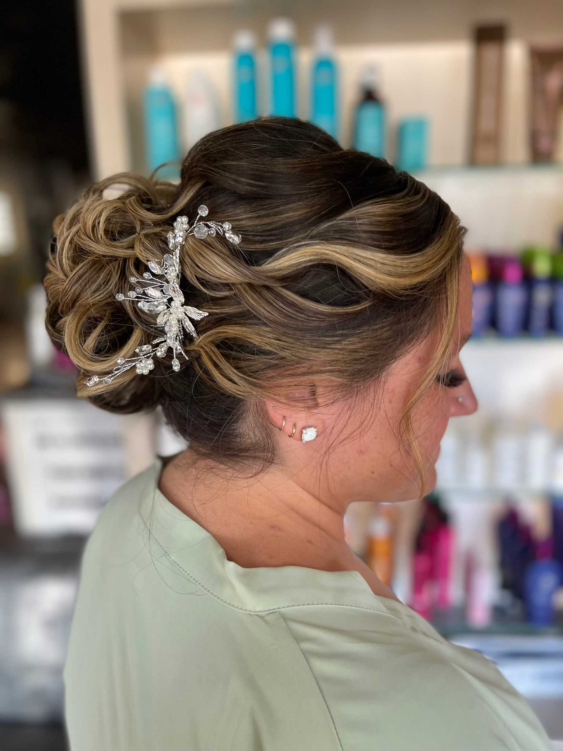 Elegant updo with decorative silver hairpiece in a salon.